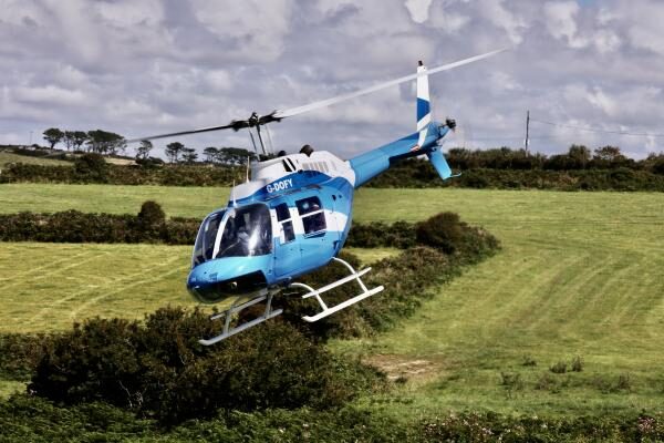 Helicopter above field and hedge