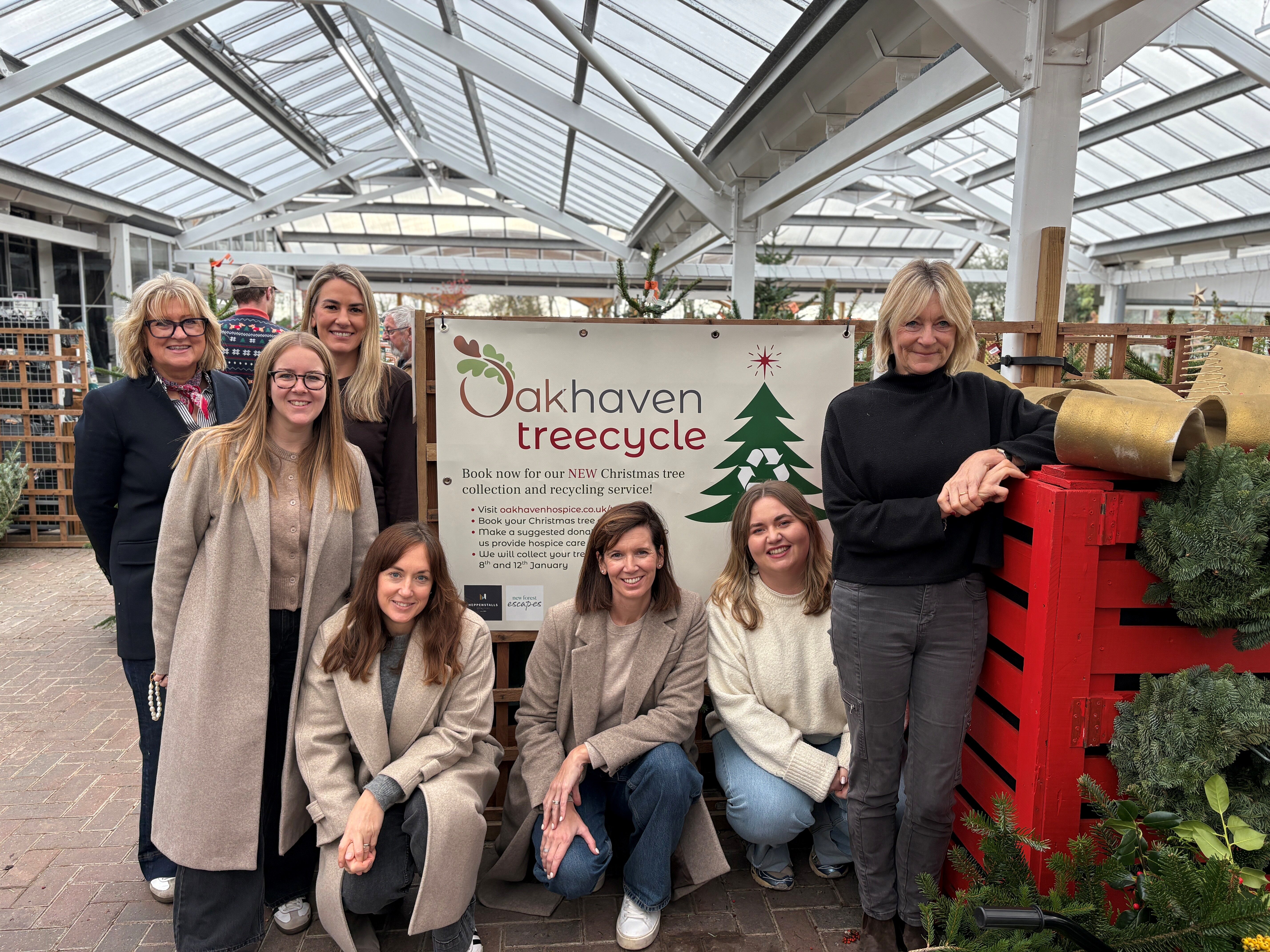 New Forest Escapes team in front of Oakhaven treecycle poster